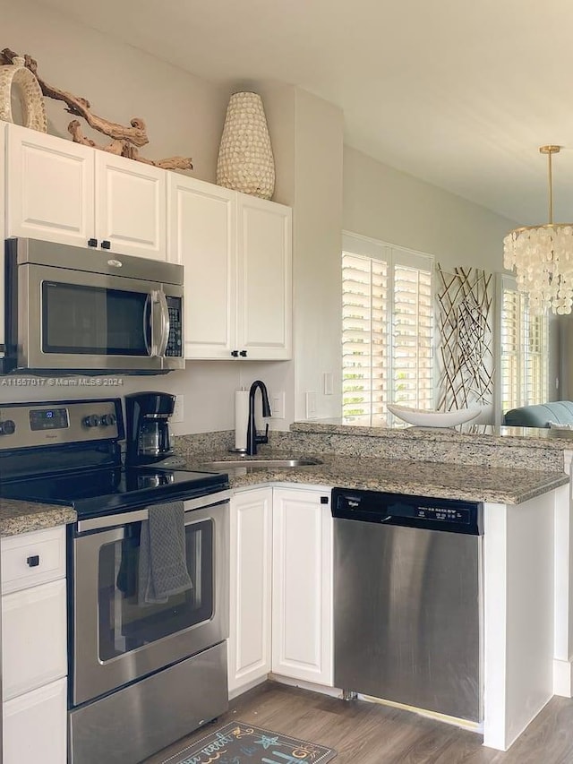 kitchen with a notable chandelier, appliances with stainless steel finishes, dark wood-type flooring, and white cabinets