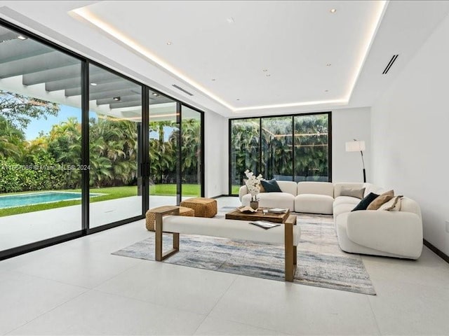 tiled living room with a wealth of natural light and a raised ceiling