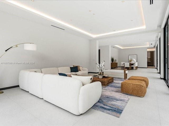 tiled living room featuring a tray ceiling