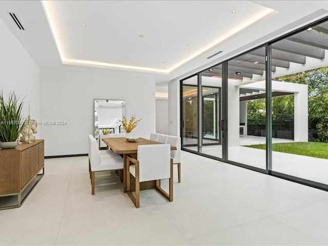 tiled dining room featuring a raised ceiling