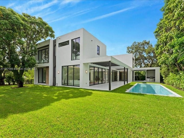 rear view of house featuring a patio area and a lawn