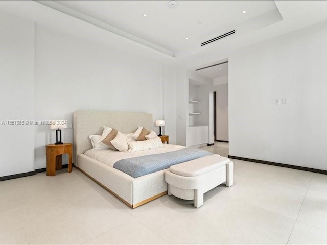 bedroom featuring a tray ceiling and light tile patterned floors