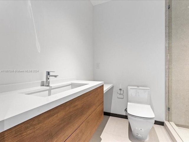 bathroom featuring toilet, a shower, vanity, and tile patterned floors