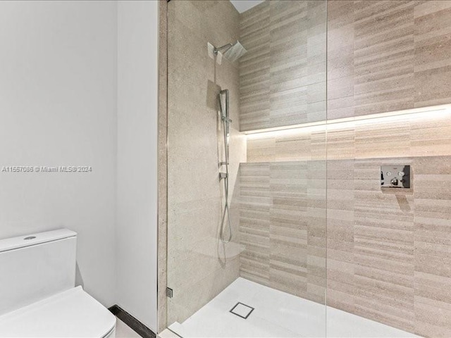 bathroom with toilet and a shower with door