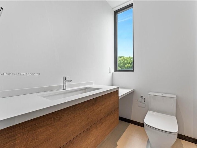 bathroom with tile patterned flooring, toilet, and vanity