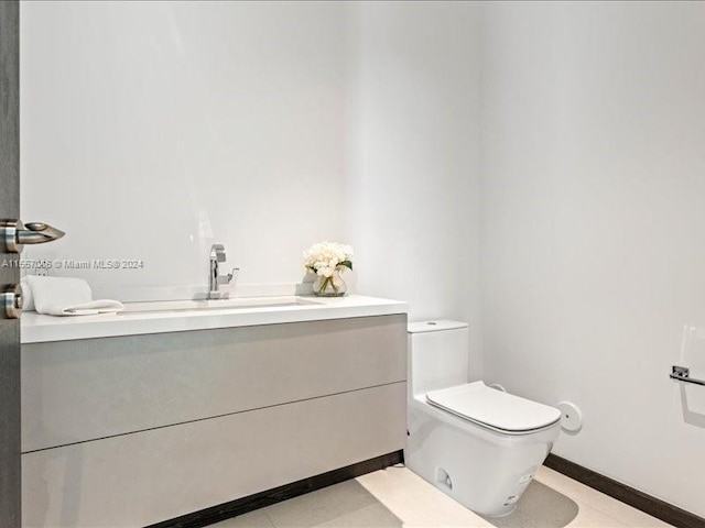 bathroom featuring toilet, vanity, and tile patterned floors