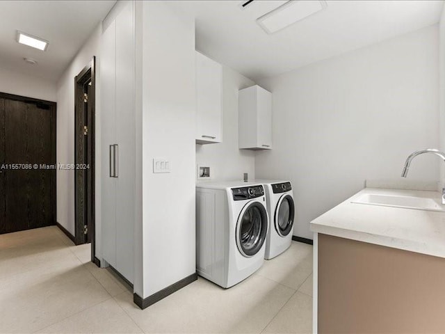 laundry room with sink, light tile patterned floors, cabinets, and independent washer and dryer