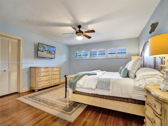 bedroom featuring ceiling fan, a closet, and dark wood-type flooring