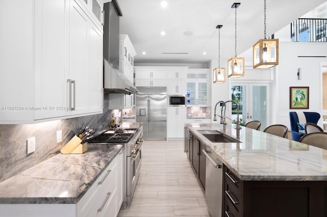 kitchen featuring built in appliances, a kitchen island with sink, and sink