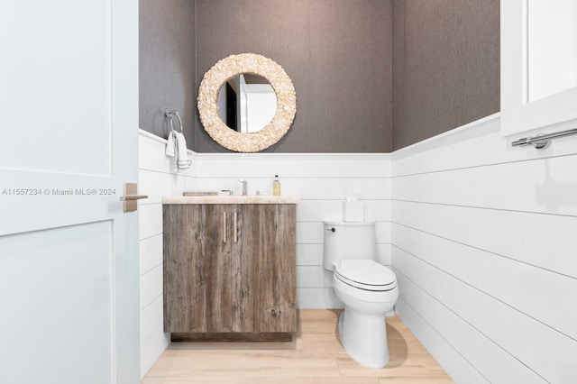 bathroom featuring toilet, vanity, and tile walls