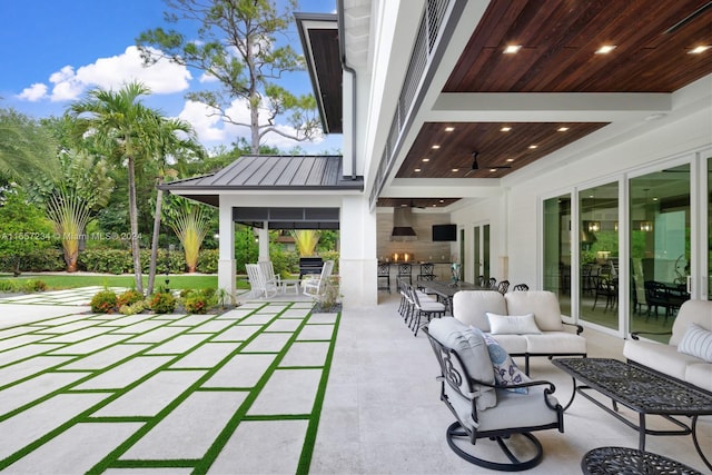 view of patio with exterior bar, an outdoor hangout area, and ceiling fan