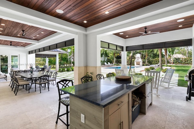 kitchen with light tile floors, wooden ceiling, ceiling fan, french doors, and dark stone countertops