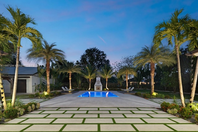 pool at dusk featuring a patio