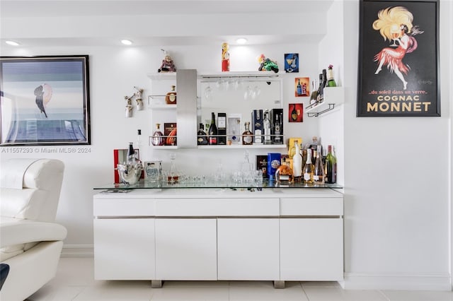 bar featuring white cabinetry and light tile floors