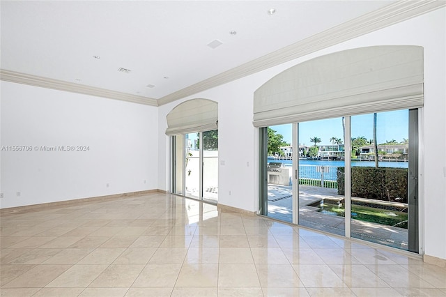 tiled empty room with ornamental molding and a water view