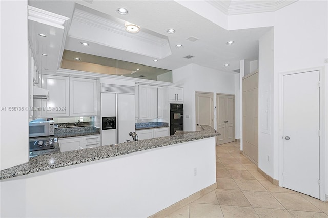 kitchen featuring white microwave, dobule oven black, built in refrigerator, white cabinets, and ornamental molding