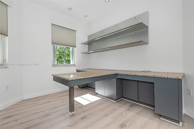 unfurnished office featuring light wood-style flooring and baseboards