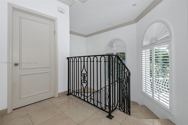 hall featuring crown molding and light tile patterned floors