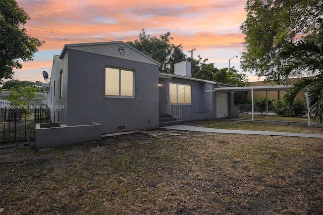 back house at dusk featuring a yard