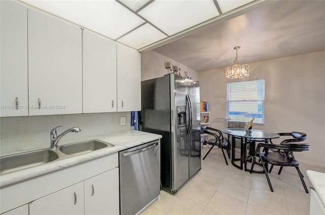 kitchen with sink, white cabinets, hanging light fixtures, an inviting chandelier, and stainless steel appliances