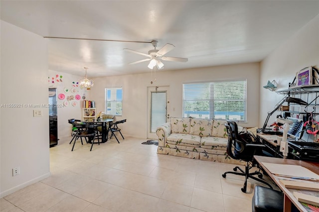 tiled home office featuring ceiling fan with notable chandelier and plenty of natural light