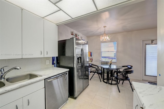 kitchen with pendant lighting, sink, white cabinetry, stainless steel appliances, and decorative backsplash