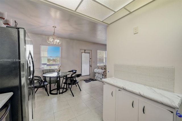 dining room with an inviting chandelier and light tile patterned floors