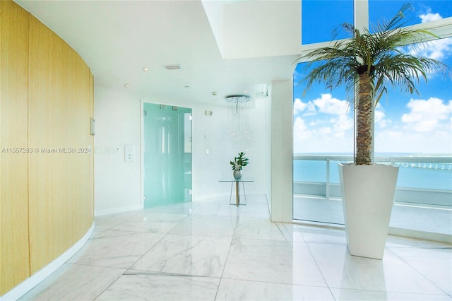 hall with a water view and light tile floors