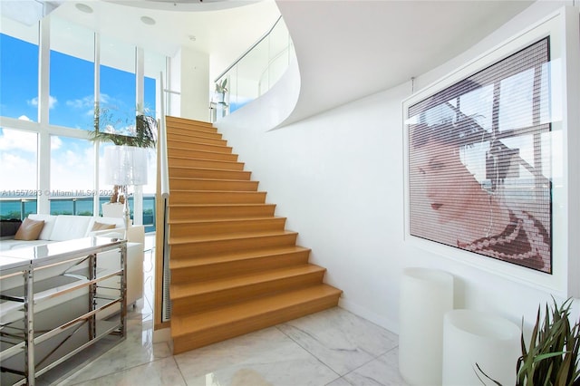 stairway featuring light tile floors and a water view