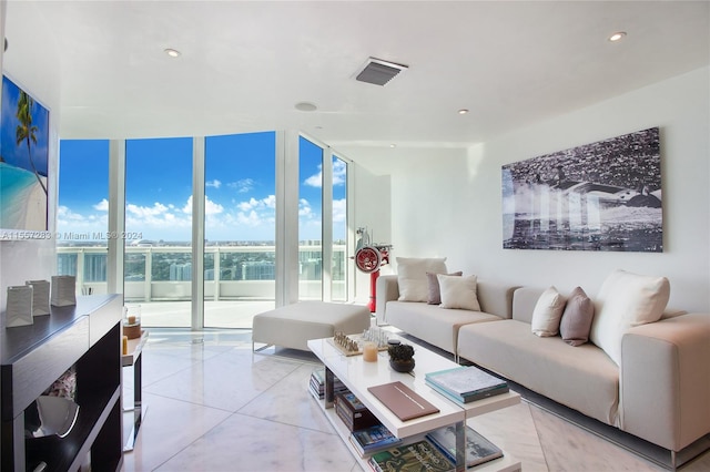 living room with light tile flooring and a wall of windows