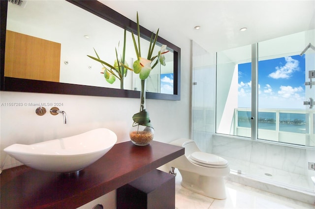 bathroom with vanity, tile floors, tiled shower, a water view, and toilet