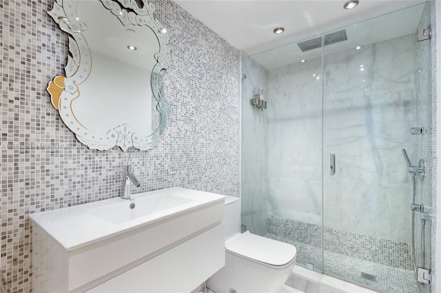 bathroom with toilet, a shower with shower door, vanity, tile walls, and backsplash