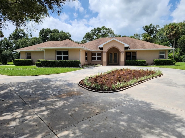 single story home featuring a front lawn