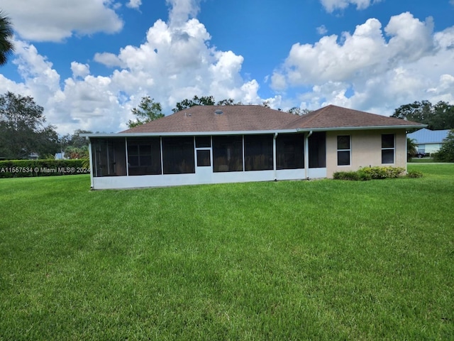 back of property featuring a sunroom and a lawn