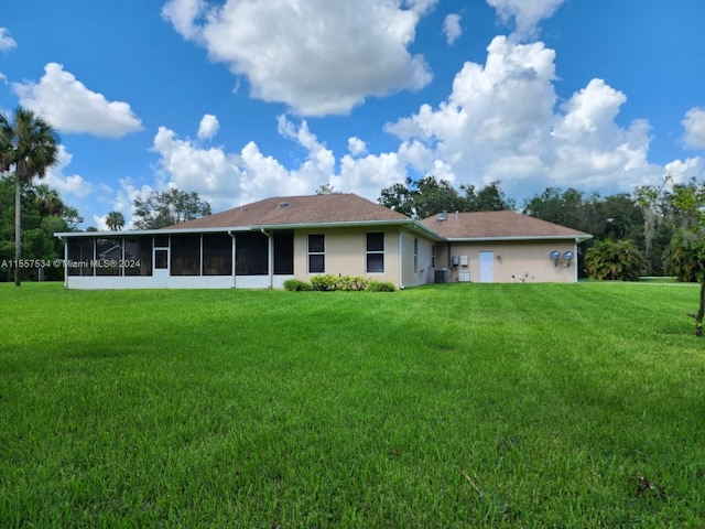 back of property with a sunroom and a lawn