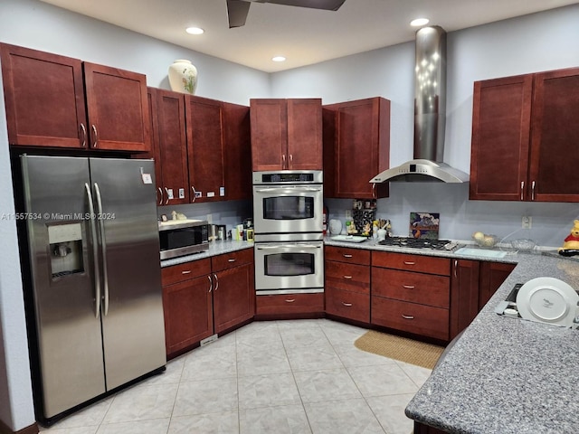 kitchen with light tile floors, light stone countertops, appliances with stainless steel finishes, and exhaust hood