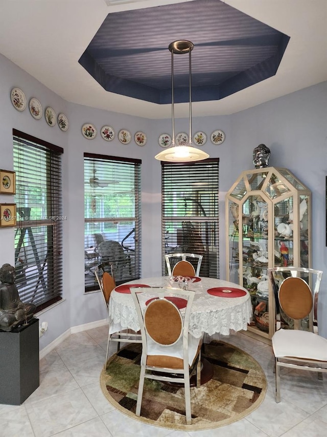 tiled dining room with a tray ceiling and a wealth of natural light