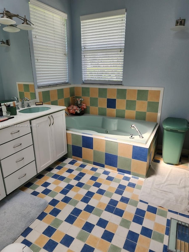 bathroom with vanity, tile flooring, and tiled tub