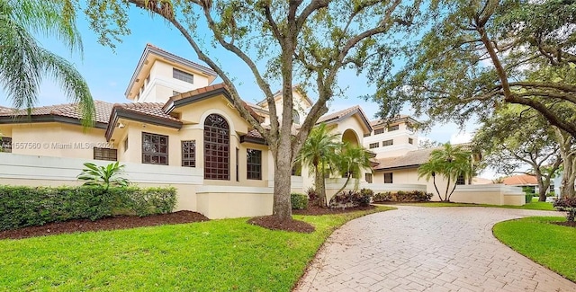 mediterranean / spanish home with a front yard