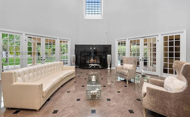 living room featuring light colored carpet, plenty of natural light, french doors, and a tiled fireplace