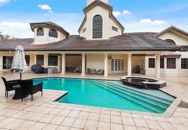 view of swimming pool with an in ground hot tub and a patio