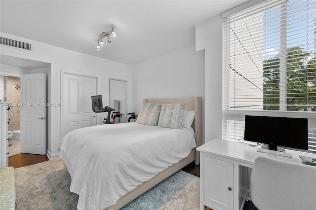 bedroom featuring a closet, light hardwood / wood-style flooring, and track lighting