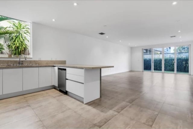 kitchen with light stone countertops, stainless steel appliances, white cabinetry, and sink