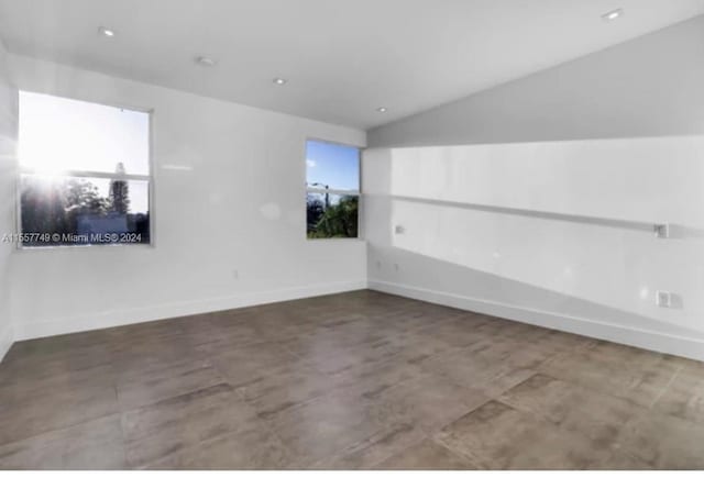 unfurnished room featuring vaulted ceiling