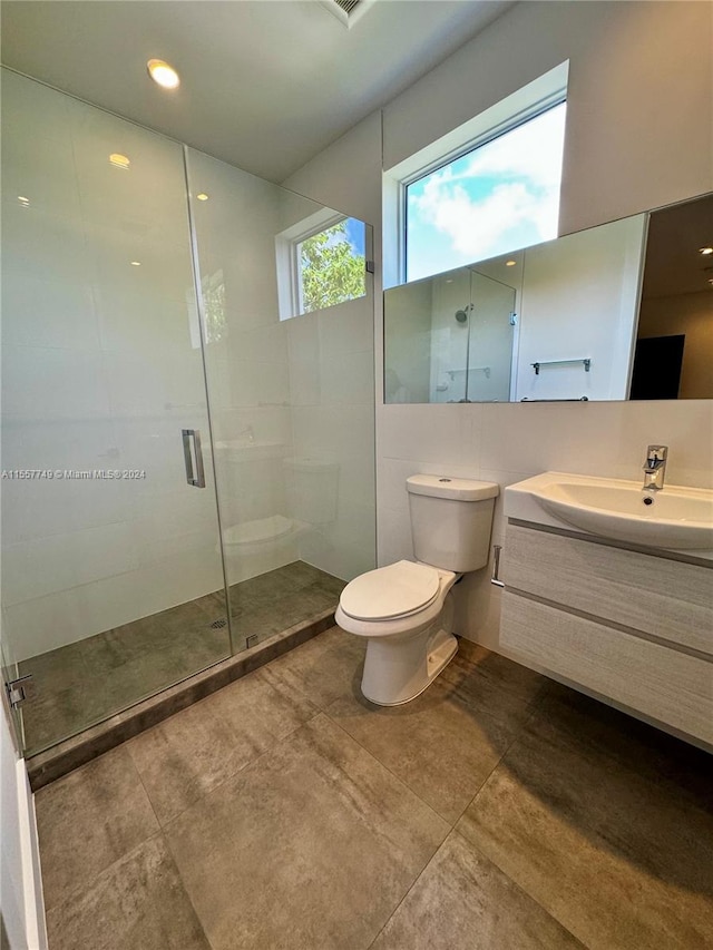 bathroom featuring vanity, toilet, and an enclosed shower