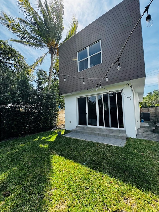 back of house featuring a lawn and a patio