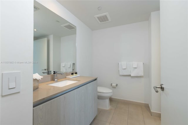 bathroom featuring toilet, tile flooring, and oversized vanity