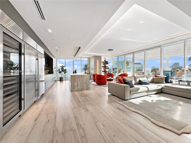 living room with a wealth of natural light, expansive windows, and light hardwood / wood-style floors