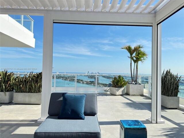 view of patio / terrace with a pergola and a water view