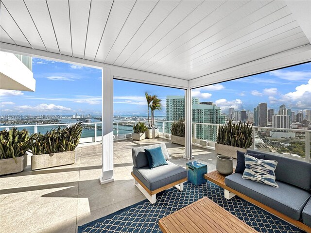 sunroom with wooden ceiling, a water view, and a healthy amount of sunlight